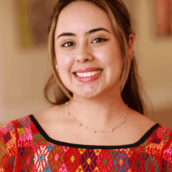 Dania Verbena smiling at the camera from the Vital Voices Headquarters.