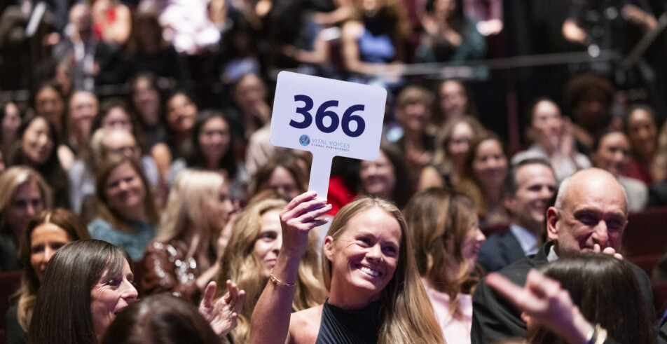 A live auction participant proudly raises her paddle to donate to the Vital Voices mission.